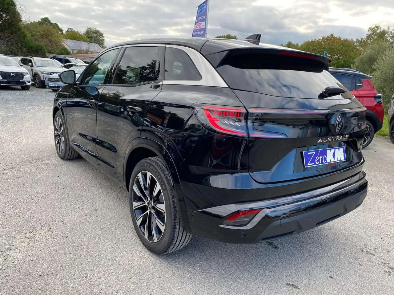 Renault Austral noir étoilé en vue 3/4 arrière droit, jantes alliage 19 pouces Komah diamantées noires visibles.