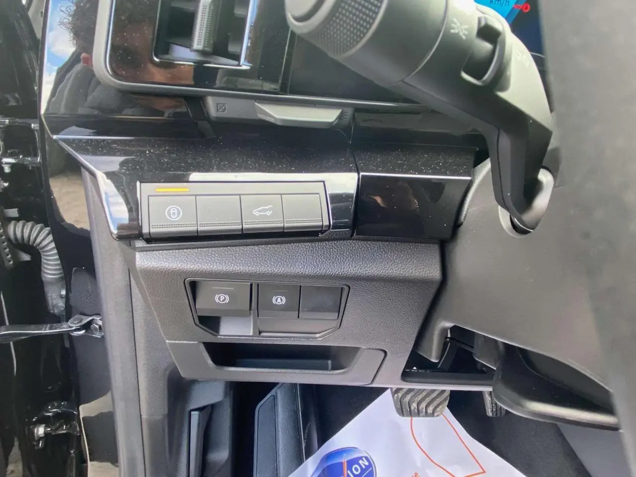 Vue rapprochée des commandes sous le tableau de bord côté gauche du Renault Austral Noir Étoile 2025 hybride.