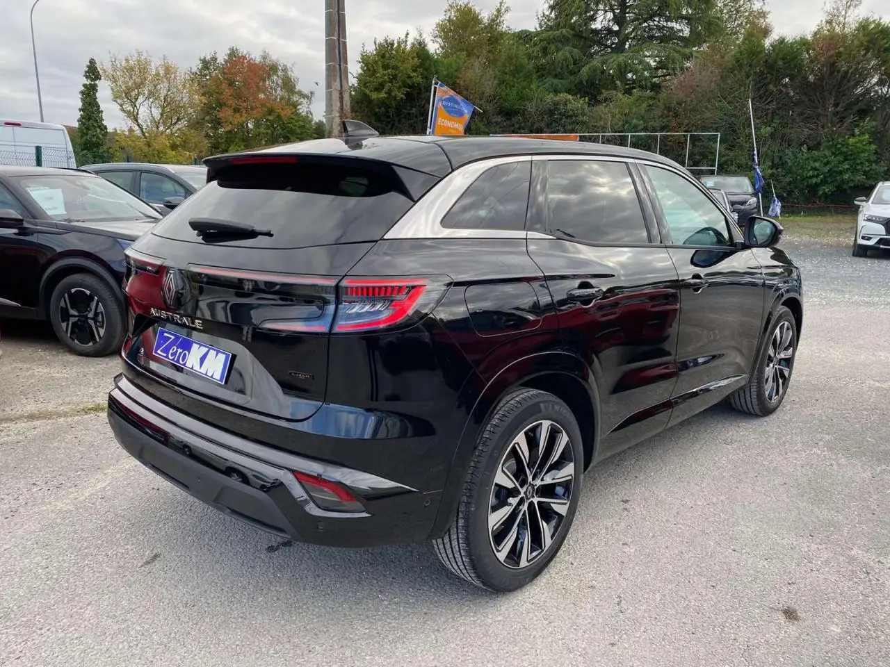 Vue 3/4 arrière droite du Renault Austral noir étoilé avec jantes alliage noires diamantées sur parking extérieur.