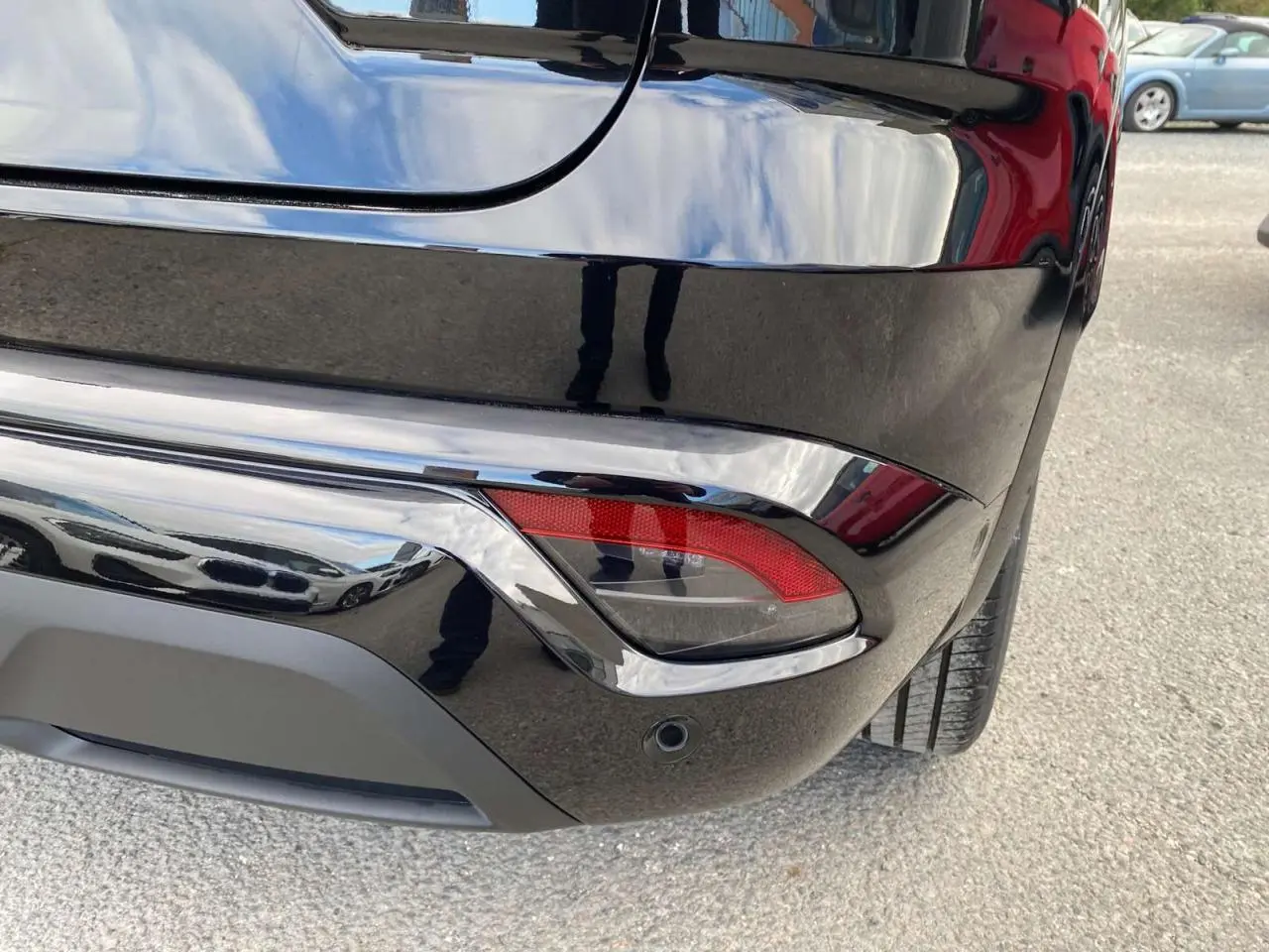 Gros plan sur le coin arrière droit du Renault Austral noir étoilé, mettant en valeur le feu arrière et le pare-chocs lustré.