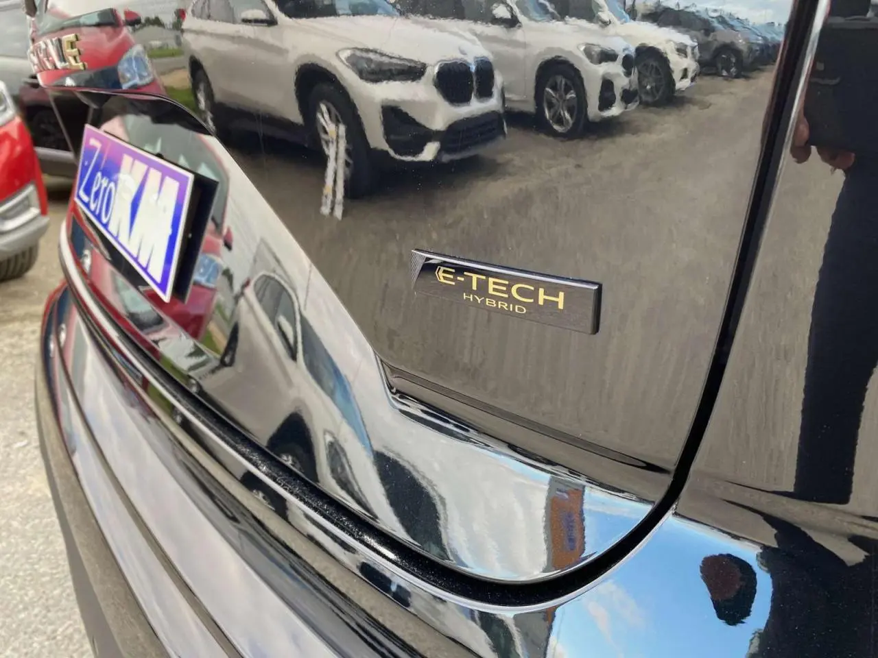 Gros plan sur le hayon arrière noir étoilé du Renault Austral E-TECH Hybrid avec logo distinctif E-TECH visible.