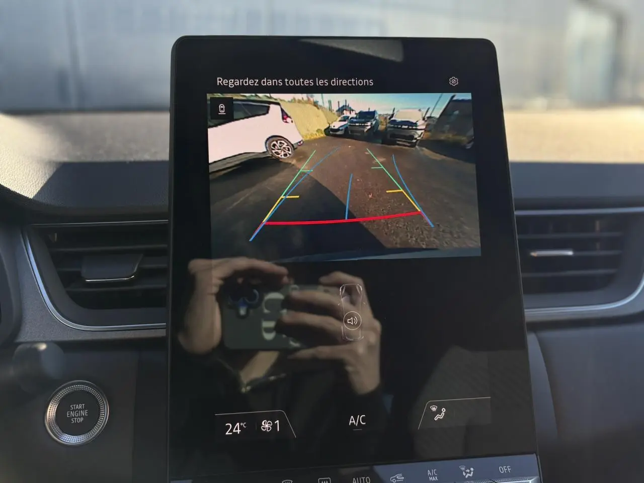 Écran central du Renault Captur 2025 montrant la caméra de recul avec lignes de guidage colorées, intérieur noir.