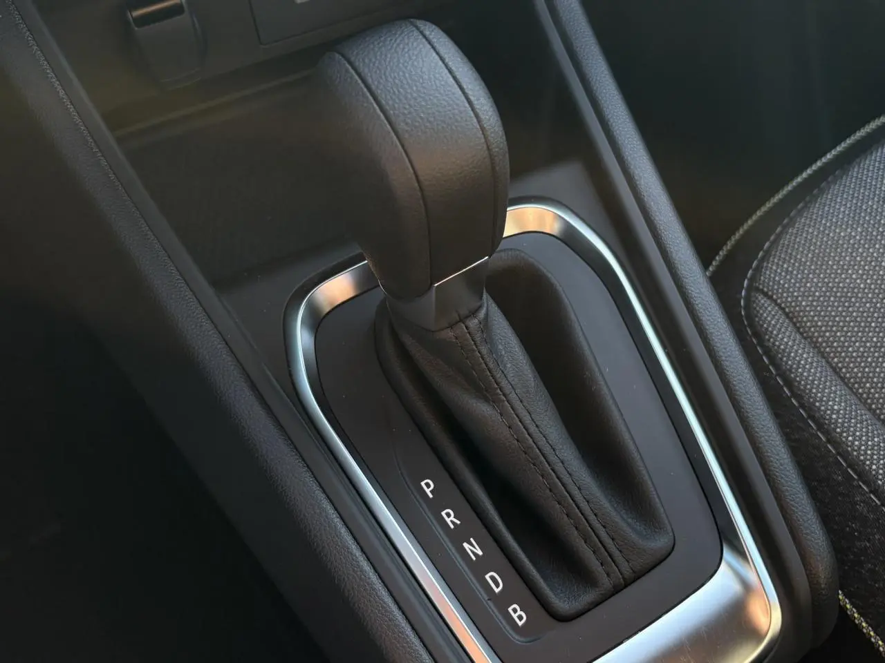 Gros plan sur la commande de la boîte automatique du Renault Captur 2025, cuir noir et contour argenté visible.