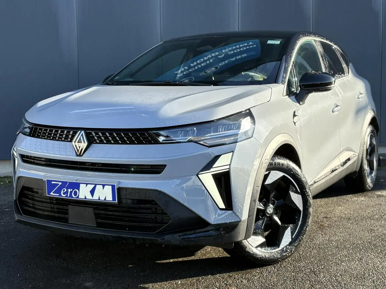 Renault Captur 2025 gris Rafale et noir, vue 3/4 avant droit, jantes noires et calandre moderne lumineuse.