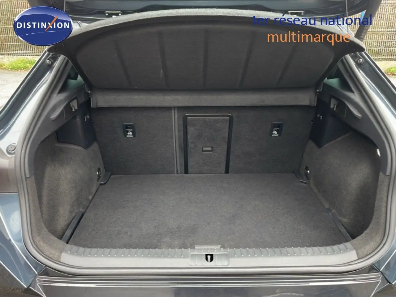 Coffre ouvert vu de l'arrière d'une CUPRA Formentor gris magnétique métal, montrant un espace de chargement propre et spacieux.