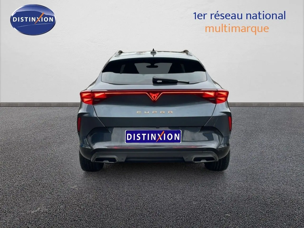 Vue arrière d'une CUPRA Formentor 1.5 eTSI 150CH DSG7 en gris magnétique métal avec feux arrière LED allumés.