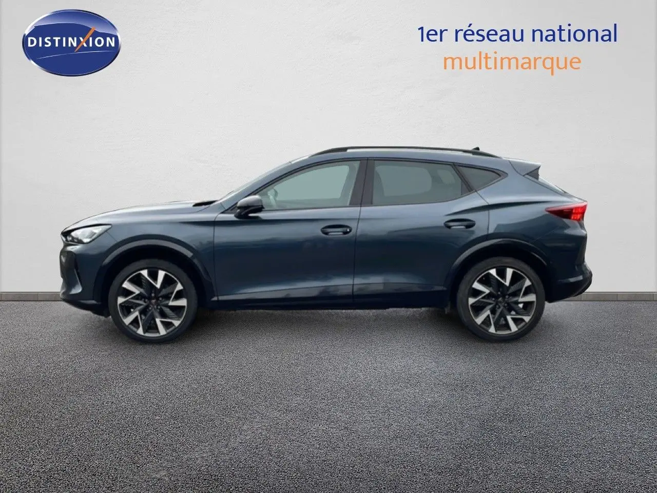 Vue de profil côté gauche d'un CUPRA Formentor gris magnétique métal avec jantes alliage bicolores, sur fond neutre.