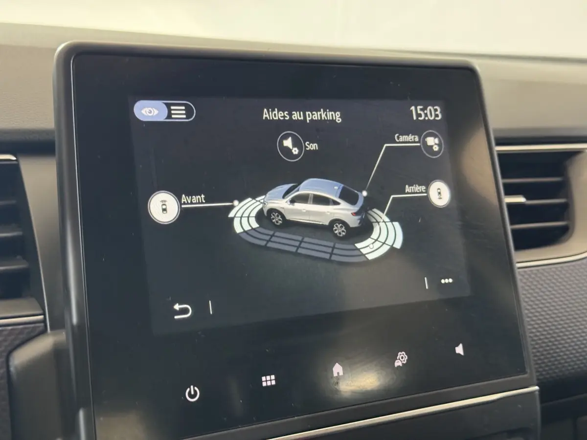 Écran tactile intérieur montrant l'aide au stationnement avec vue 3D d'un Renault Arkana gris foncé en plan rapproché.