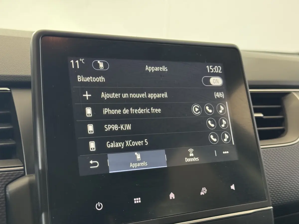 Écran tactile central de la Renault Arkana Business E-TECH 145 affichant la connexion Bluetooth, intérieur noir.