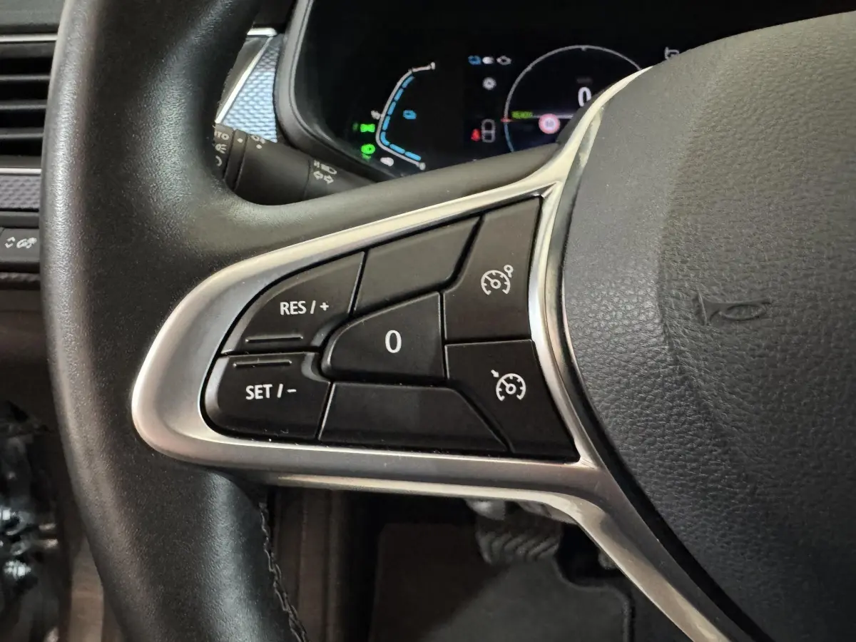 Gros plan sur les commandes de régulateur de vitesse au volant cuir noir du Renault Arkana Business E-TECH 145 2022.