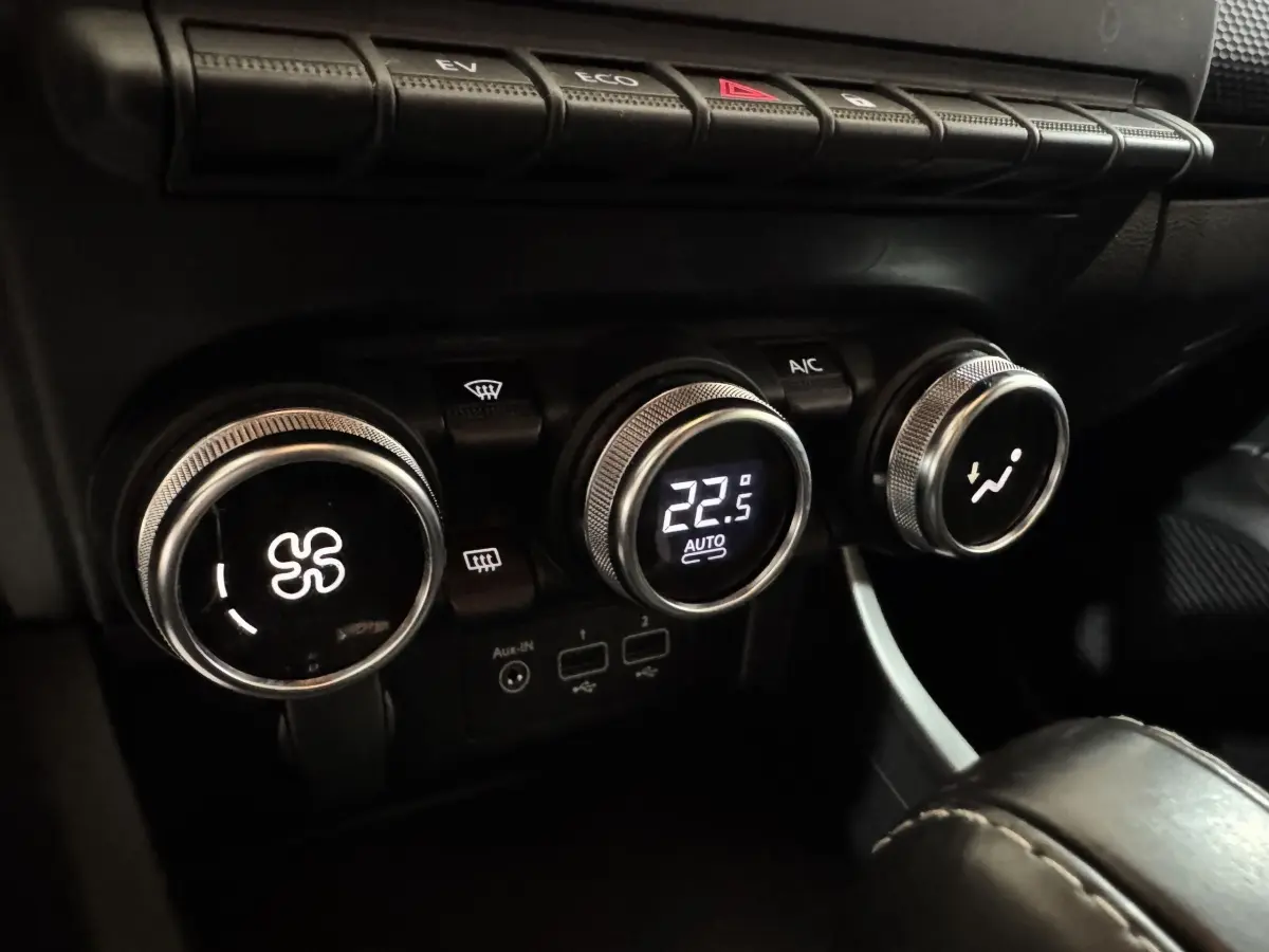 Gros plan sur les commandes de climatisation avec affichage digital à 22,5°C dans l’habitacle noir du Renault Arkana Business E-TECH.