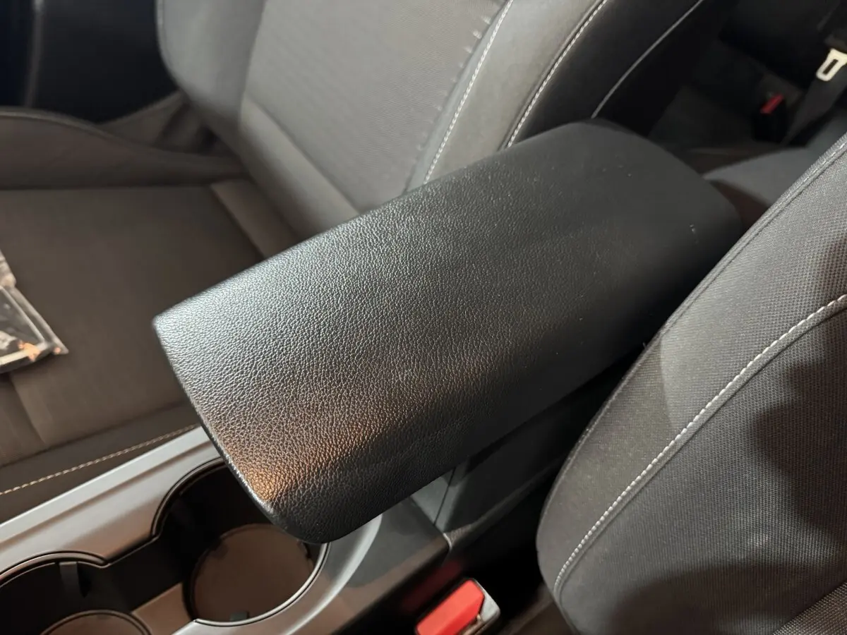 Accoudoir central noir en cuir synthétique entre les sièges avant gris foncé du Renault Arkana Business E-TECH 145.