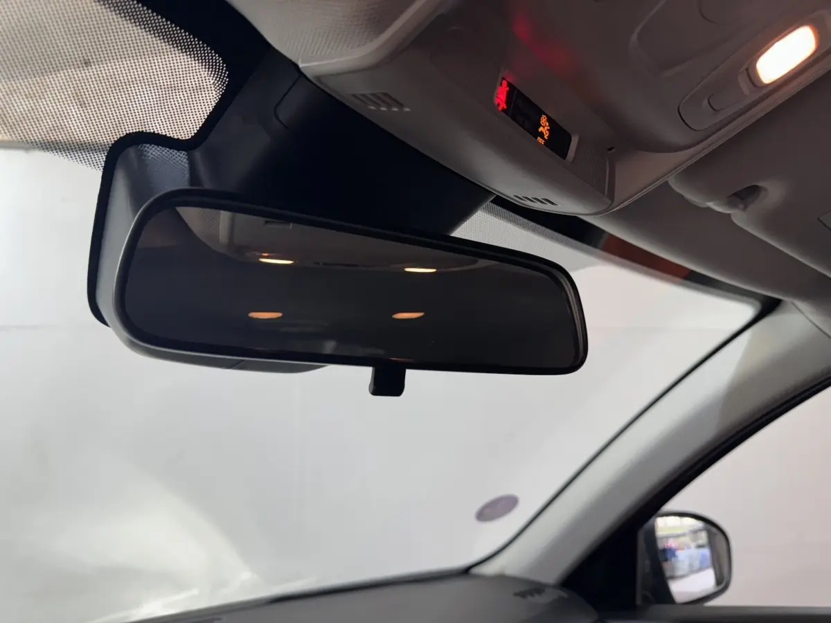 Vue intérieure centrée sur le rétroviseur intérieur du Renault Arkana Business E-TECH gris foncé, avec partie du pare-brise et rétroviseur latéral droit visible.