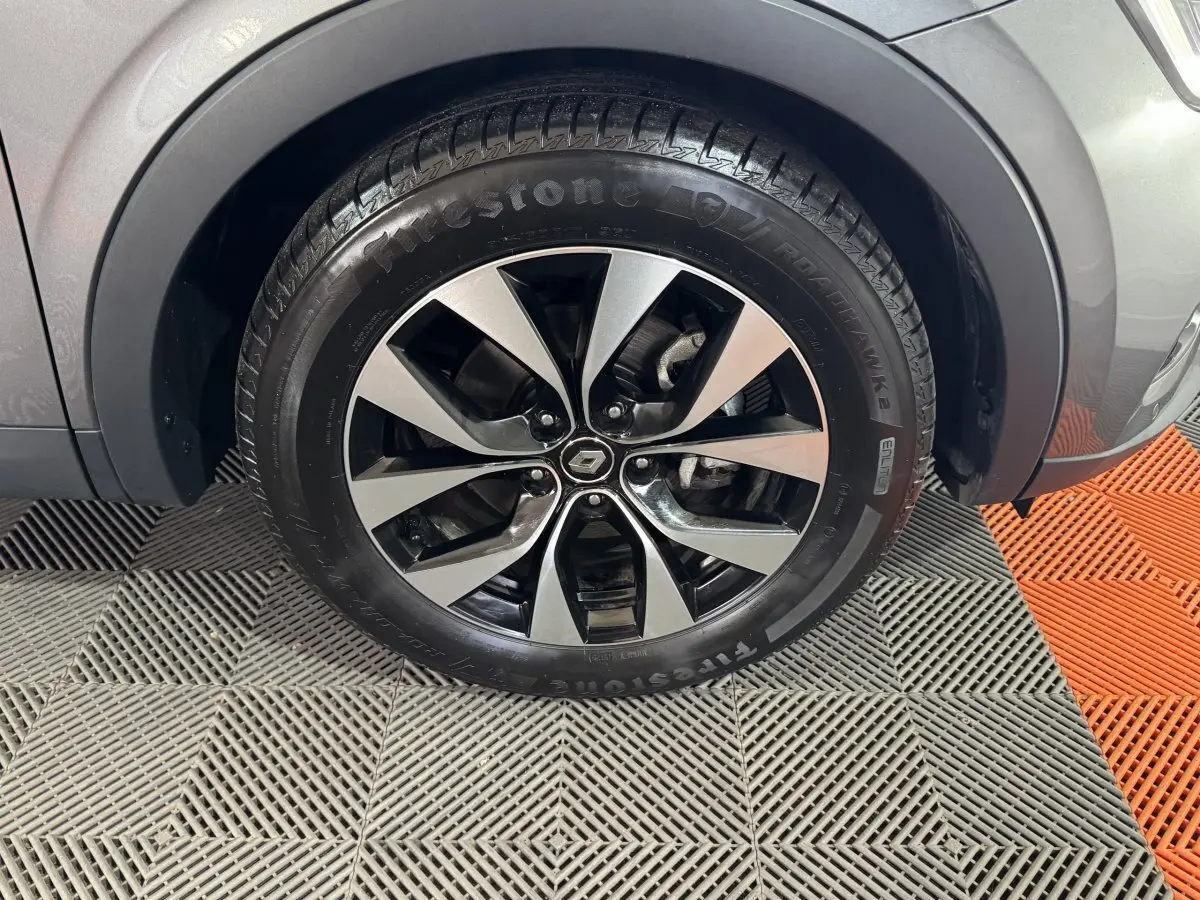 Gros plan sur la roue avant droite gris foncé d’un Renault Arkana Business E-TECH 145 avec jante alliage bicolore.