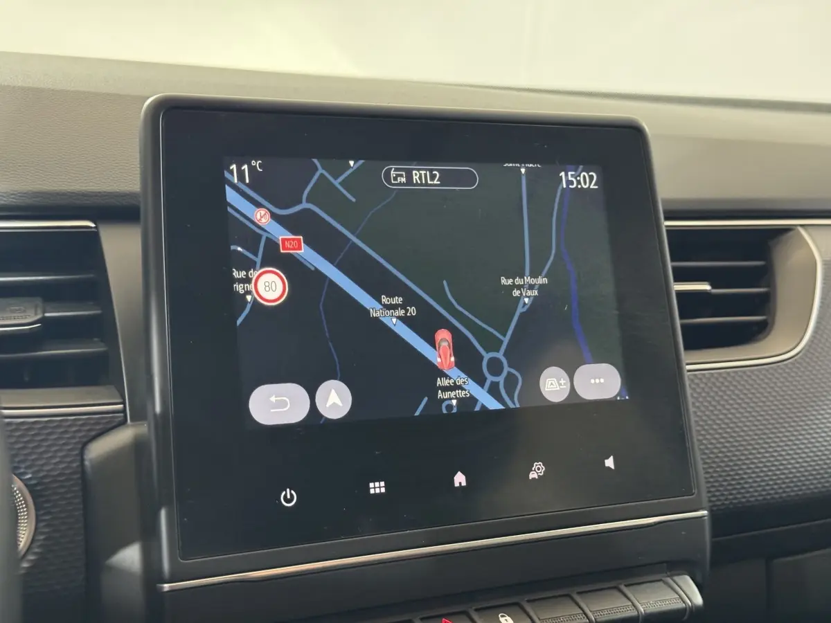 Écran tactile central affichant la navigation du Renault Arkana Business E-TECH 145, intérieur gris foncé.