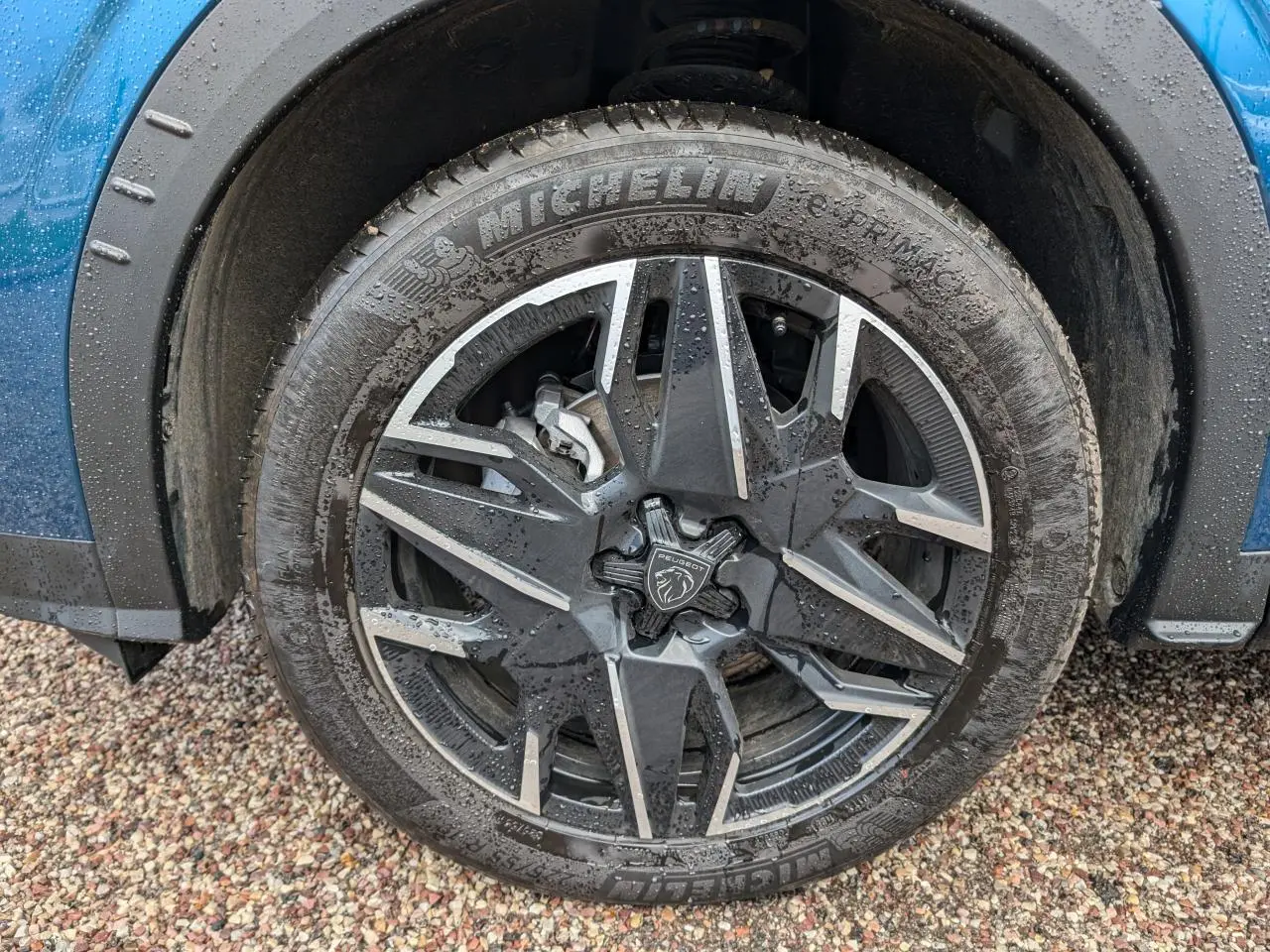 Gros plan sur la jante alliage 19'' diamantée noire et grise du Peugeot 3008 bleu métallisé, roue avant droite.