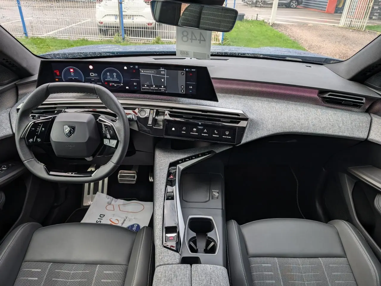 Vue intérieure avant du Peugeot 3008 GT 2025, tableau de bord avec écran panoramique et sellerie tissu gris chiné.