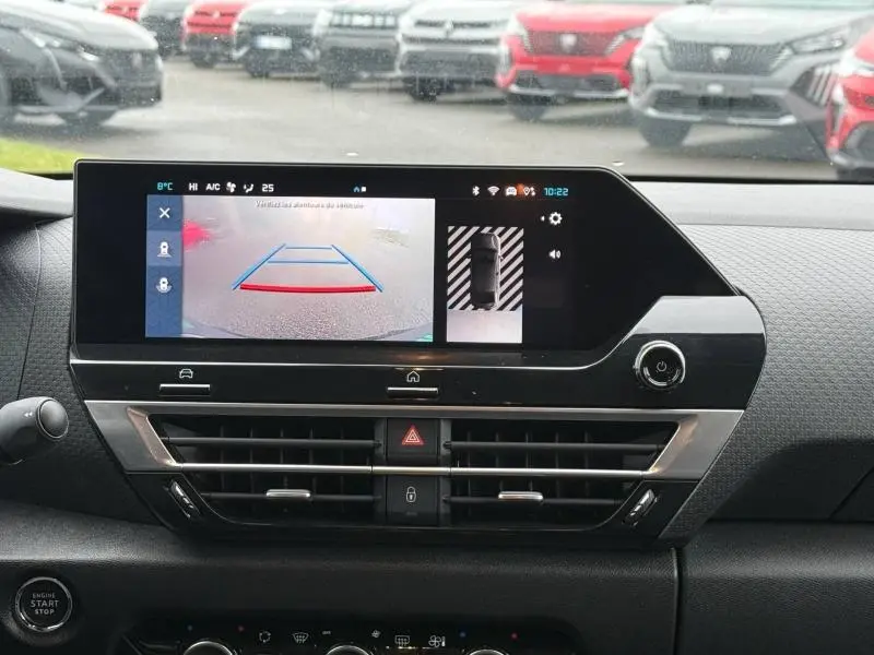 Vue intérieure du tableau de bord de la Citroën C4 X 2024, écran tactile affichant la caméra de recul et l'aide au stationnement.
