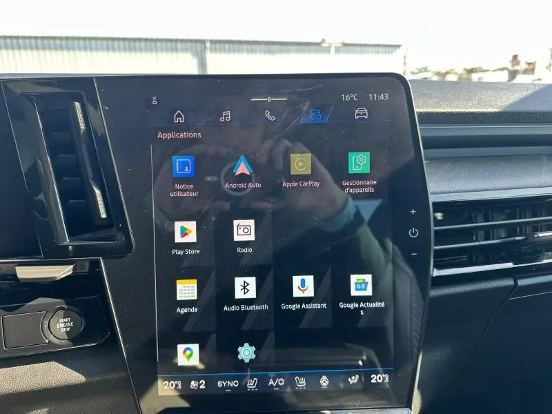 Écran tactile central du tableau de bord du Renault Rafale 1.2 E-Tech bleu, affichant les applications connectées.