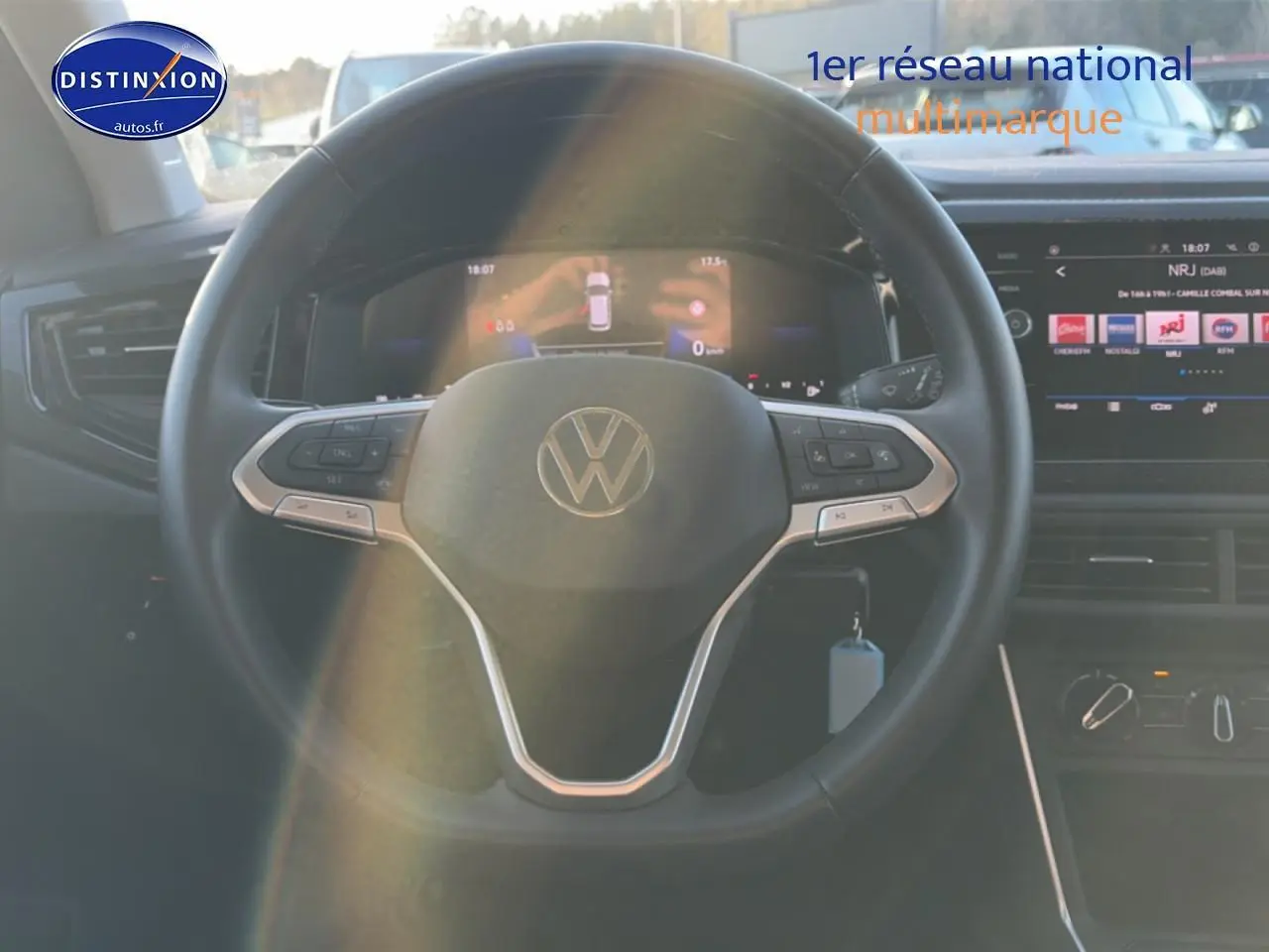 Vue intérieure centrée sur le volant cuir multifonction d'une Volkswagen Polo gris, avec tableau de bord et écran tactile visibles.