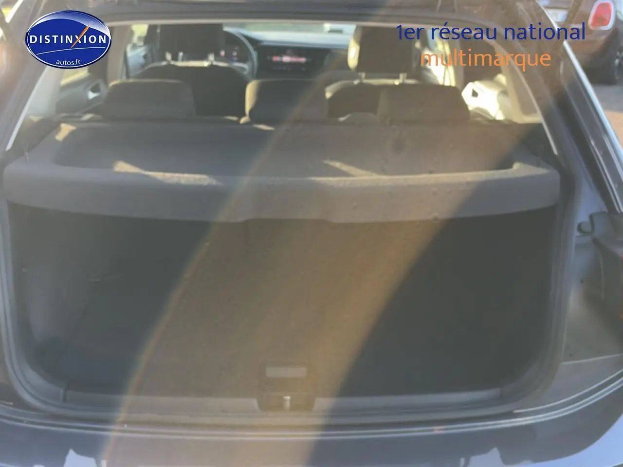 Vue arrière ouverte du coffre d'une Volkswagen Polo gris, mettant en valeur l'espace de chargement et la tablette cache-bagages.