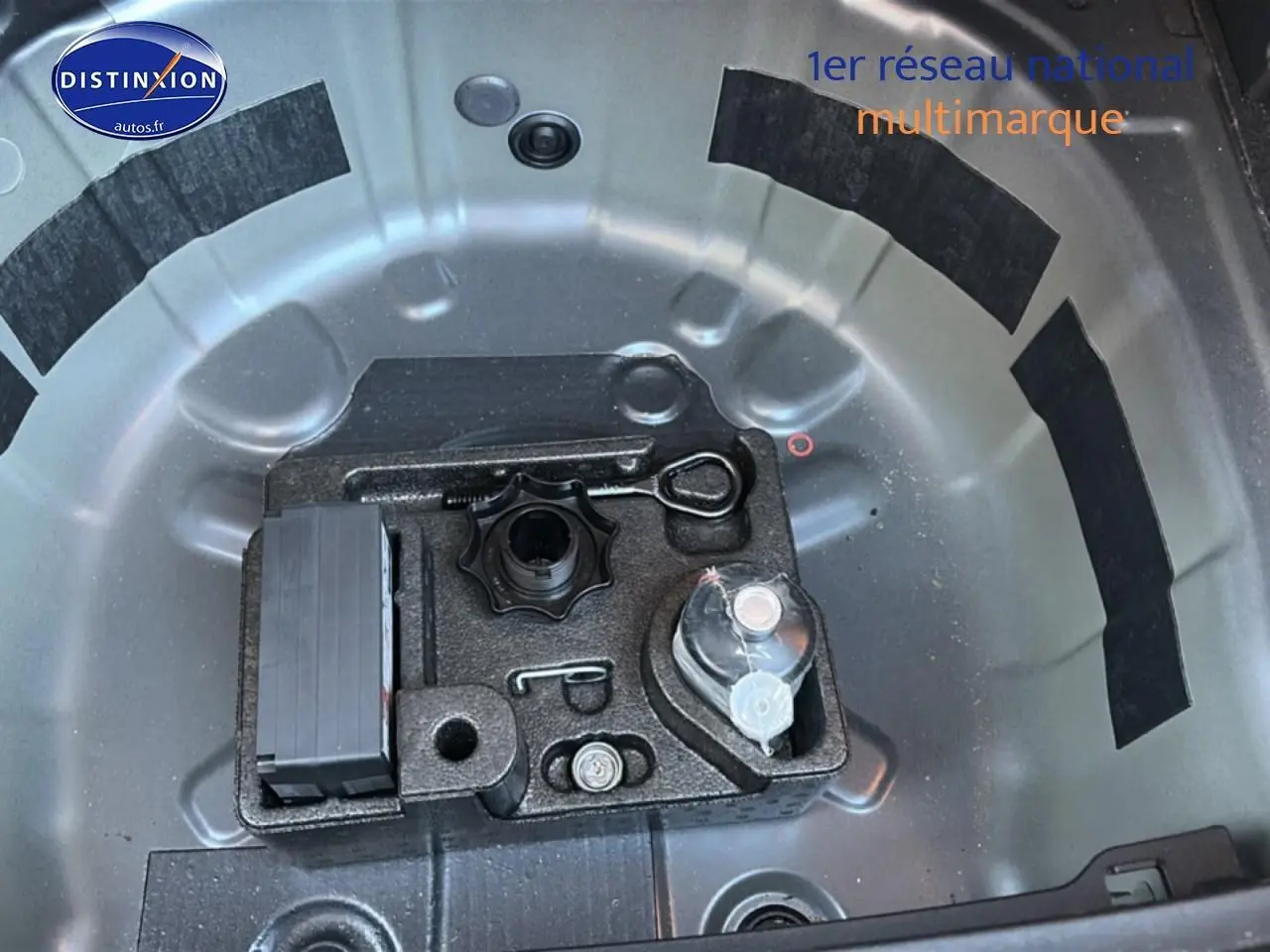Vue plongeante sur le rangement de roue de secours gris d'une Volkswagen Polo 2025 avec outils intégrés.