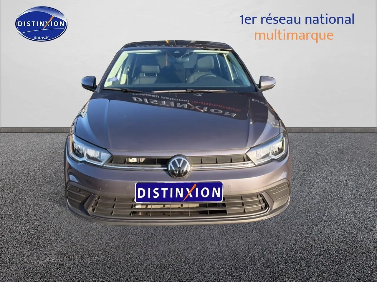 Vue frontale d'une Volkswagen Polo gris métallisé avec calandre noire et phares LED, sur fond neutre.