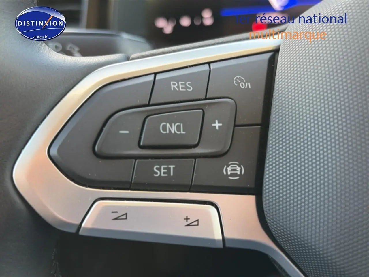 Gros plan sur les commandes multifonctions du volant cuir de la Volkswagen Polo gris 2025, version 1.0 TSI 95 VW Edition.