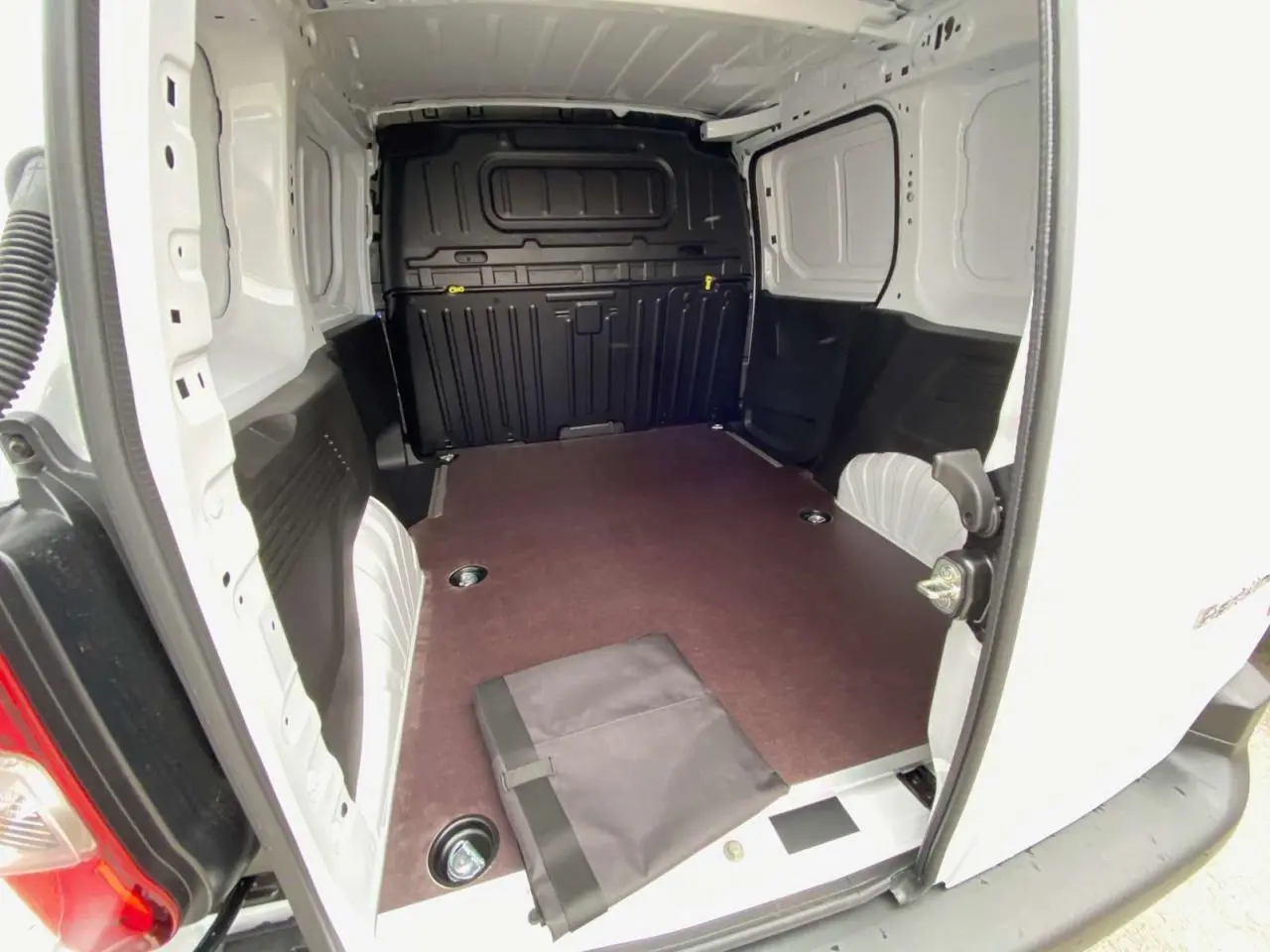 Vue intérieure arrière du Citroën Berlingo blanc 2026, montrant l’espace de chargement avec plancher bois antidérapant.