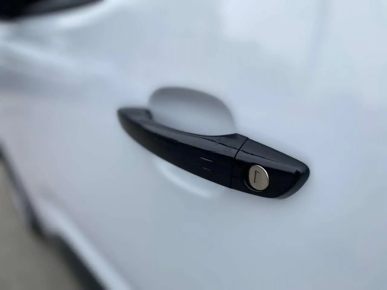 Poignée de porte noire brillante en gros plan sur la portière blanche d'un Citroën Berlingo 2026.