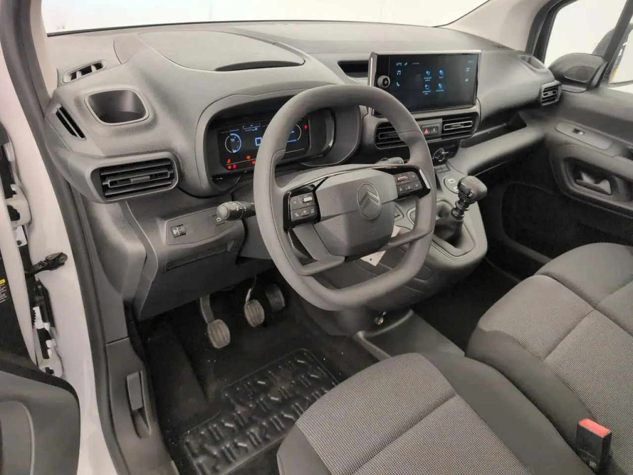 Vue intérieure côté conducteur du Citroën Berlingo blanc, tableau de bord moderne avec écran tactile et volant multifonction.
