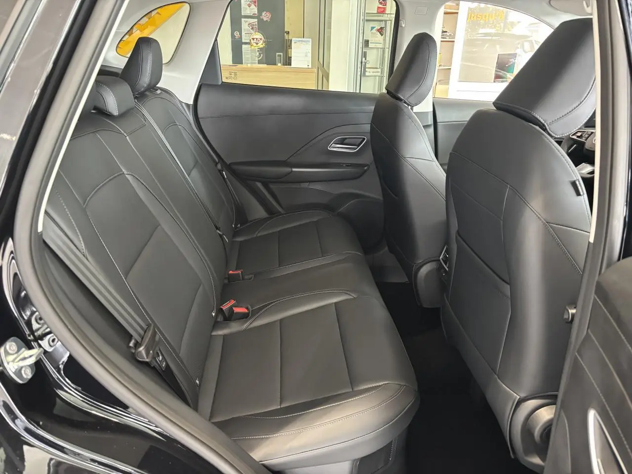 Vue intérieure côté gauche sur la banquette arrière en cuir noir du MG MOTOR ZS 1.5 Hybrid+ 2026.