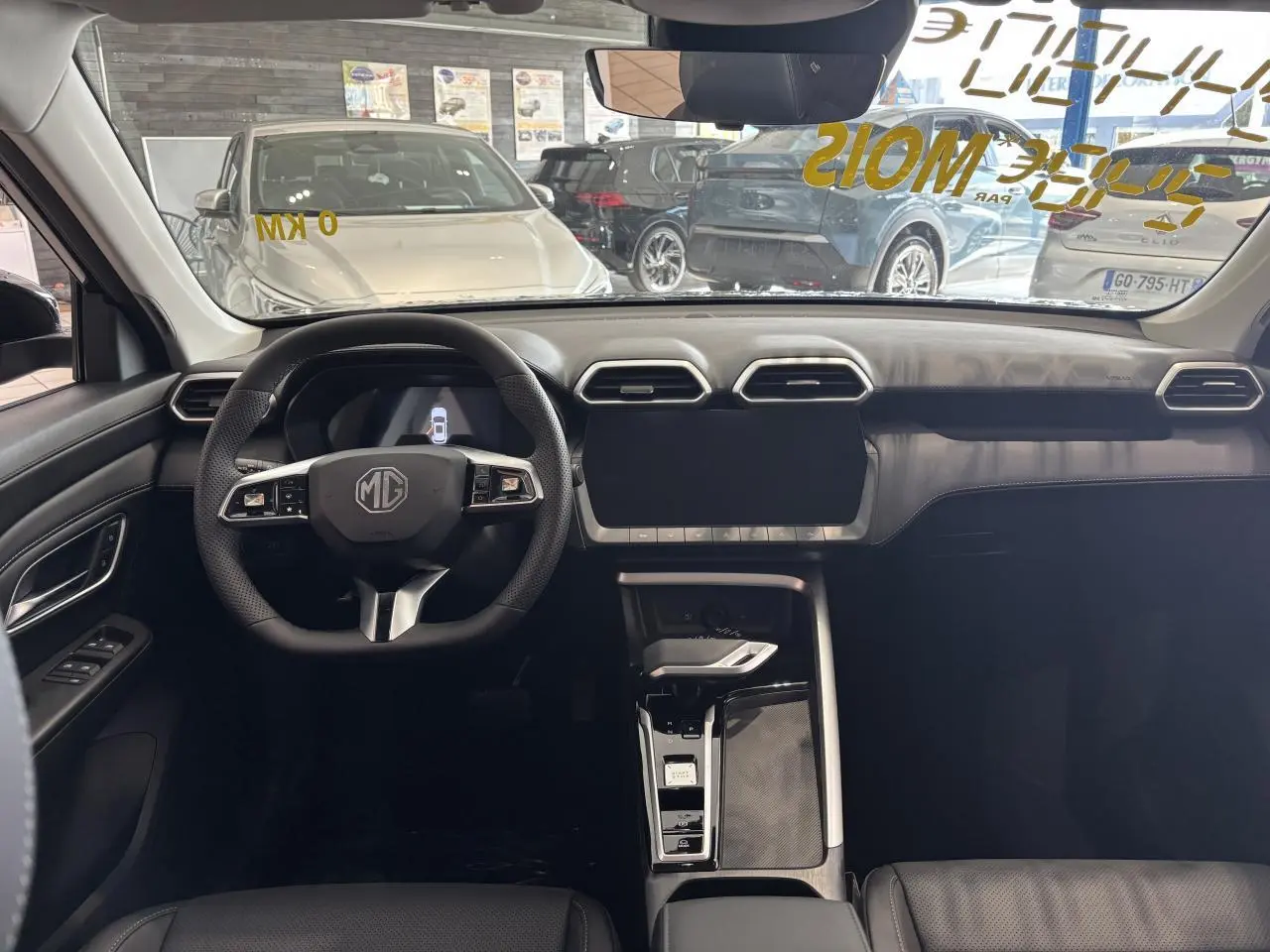 Vue intérieure avant du MG ZS 1.5 Hybrid+ noir, tableau de bord moderne avec écran tactile et volant multifonction.