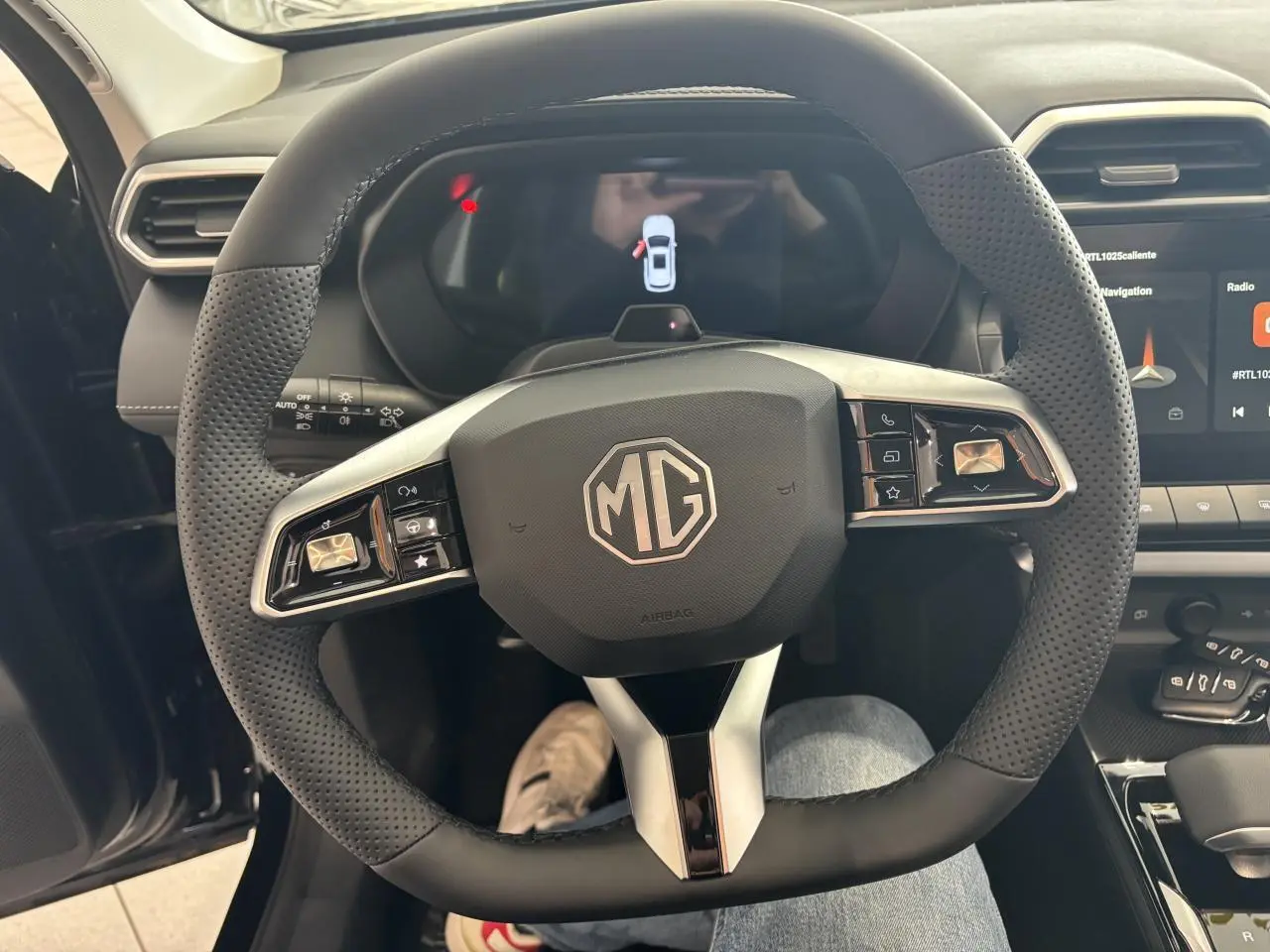 Vue rapprochée du volant noir perforé de la MG ZS 1.5 Hybrid+ 2026 avec commandes intégrées et tableau de bord numérique.