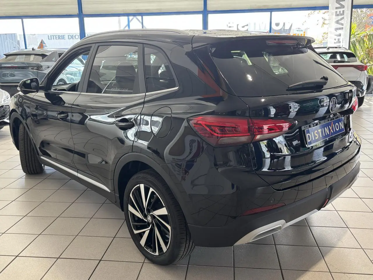 MG ZS 1.5 Hybrid+ noir métallisé vu en 3/4 arrière droit, avec jantes alliage 18 pouces et vitres surteintées.