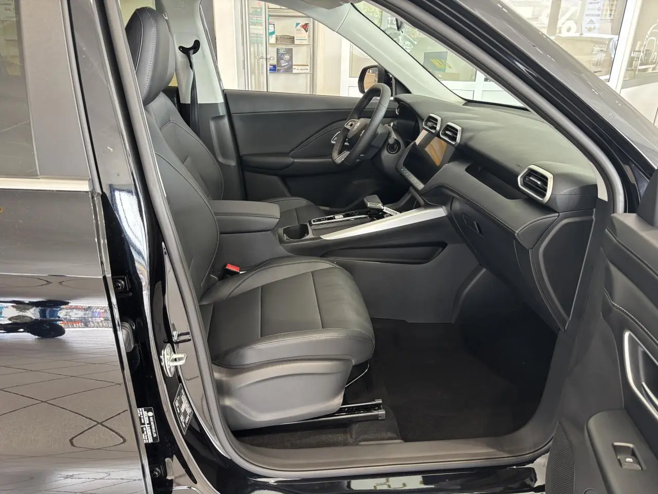 Vue intérieure côté conducteur du MG Motor ZS 1.5 Hybrid+ noir, avec sellerie cuir/similicuir et tableau de bord moderne.
