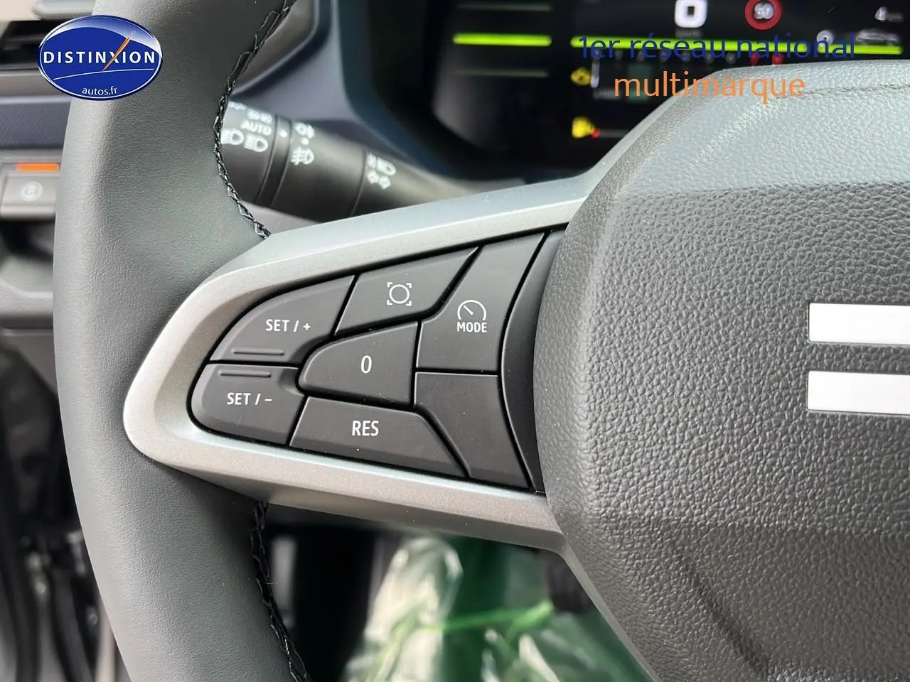 Gros plan sur les commandes multifonctions à gauche du volant du Dacia Duster gris schiste 2025, version Expression 4x2.
