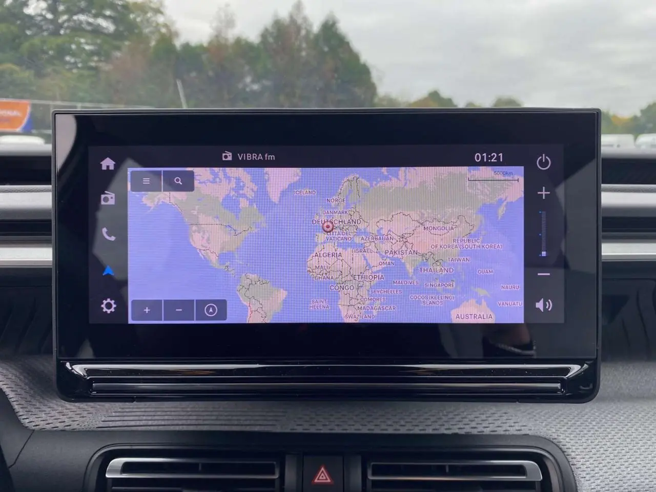 Écran tactile central de la Citroën C3 2025 affichant une carte du monde avec interface moderne et commandes tactiles.