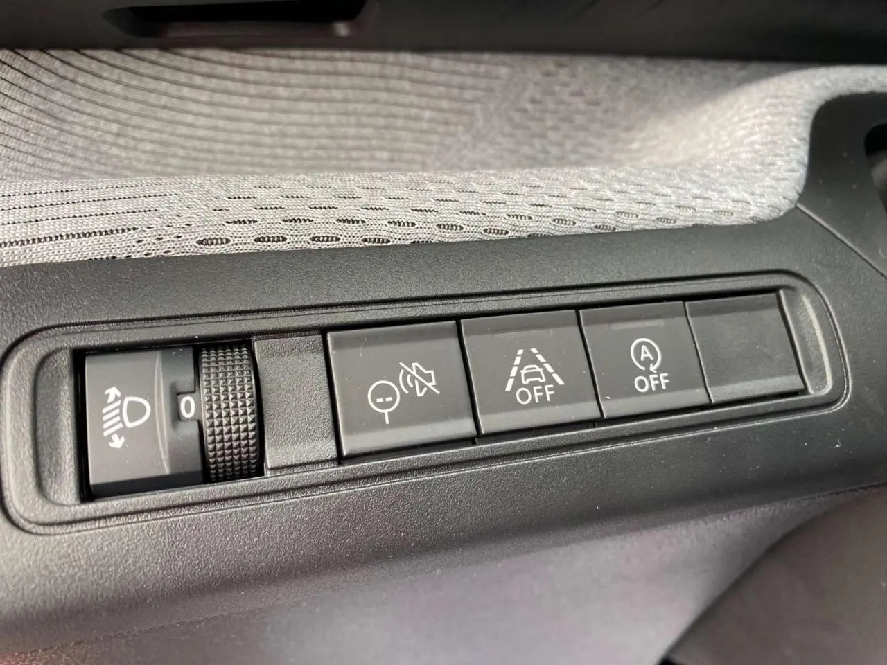 Gros plan sur les commandes noires du tableau de bord de la Citroën C3 rouge Elixir avec toit noir, version 2025.