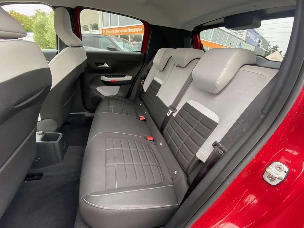 Vue intérieure côté droit de la banquette arrière noire et grise du Citroën C3 Rouge Elixir avec toit noir, 2025.