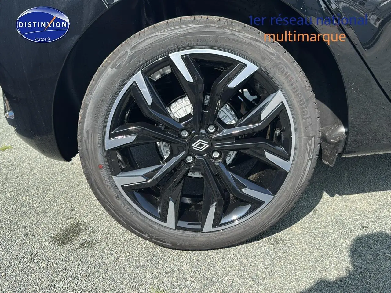 Gros plan sur la jante alu noire et argentée de la Renault Clio V noire, côté arrière droit du véhicule.