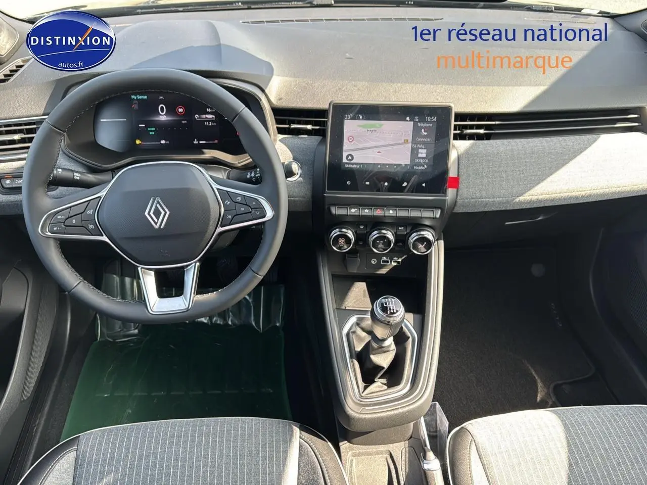Vue intérieure avant de la Renault Clio V noire, volant multifonction, écran tactile et levier de vitesse manuel visibles.