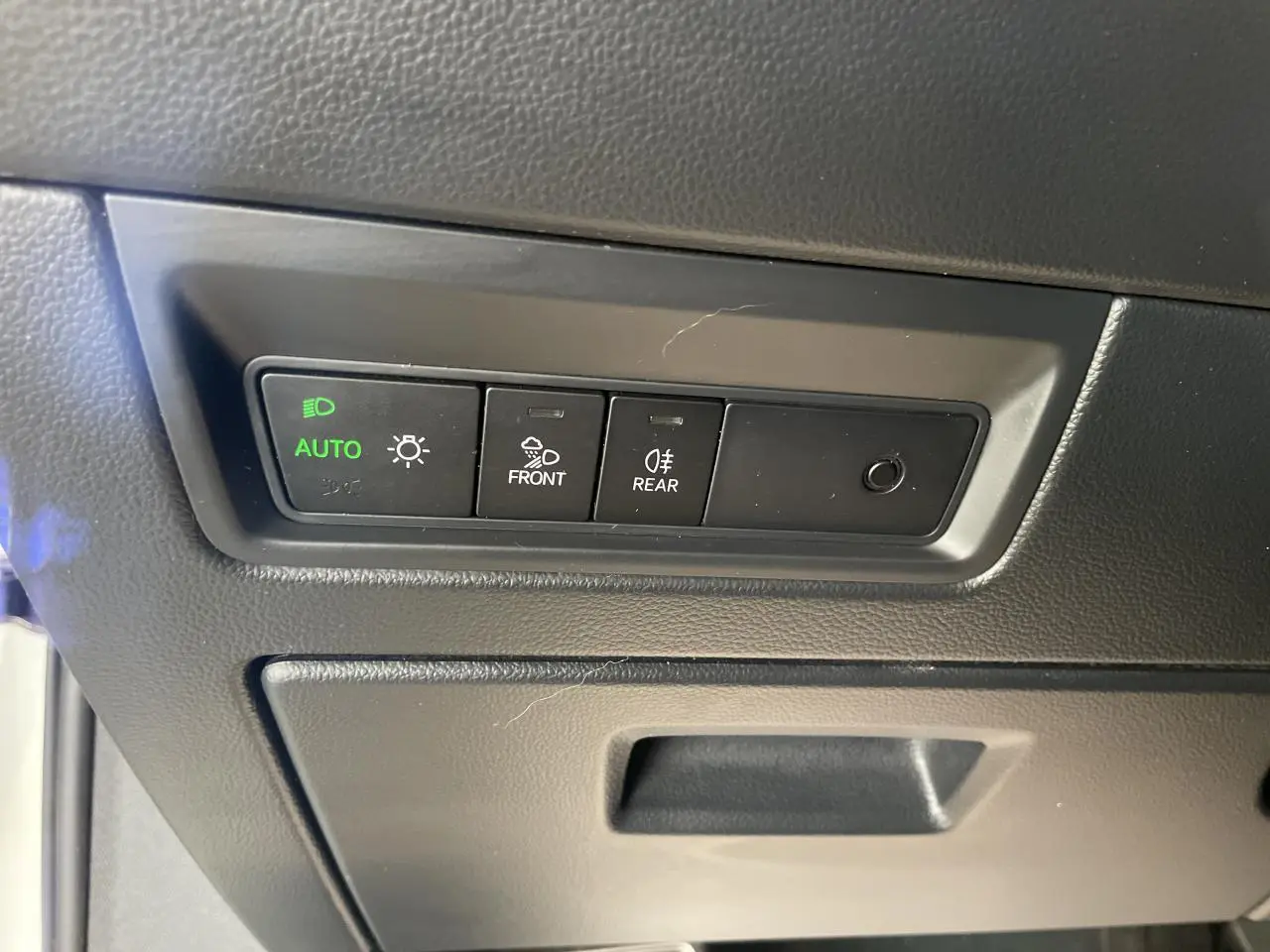 Gros plan sur les commandes d’éclairage et anti-brouillard du Volkswagen Touareg blanc, intérieur côté conducteur.
