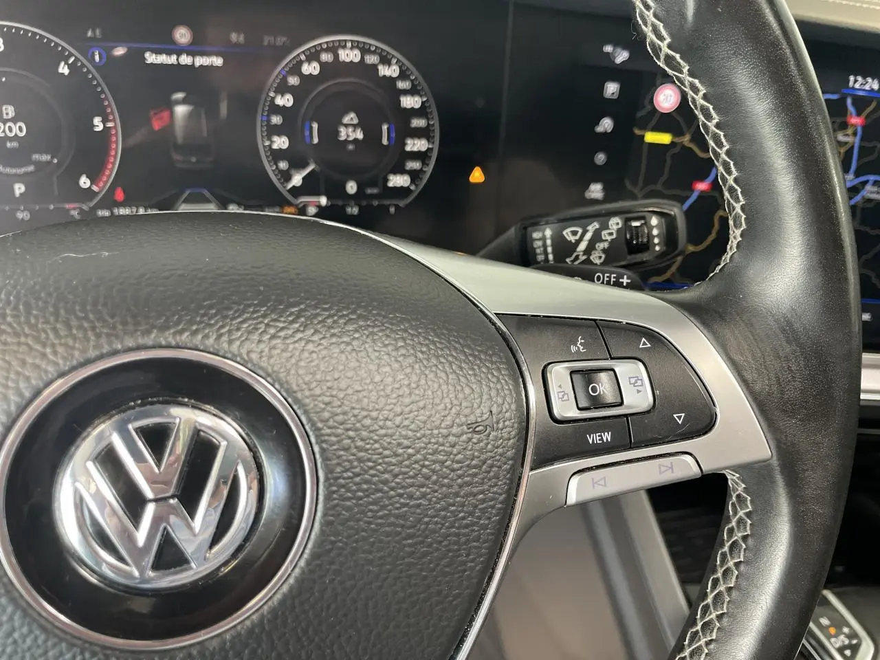 Gros plan sur le volant cuir noir R-Line avec commandes multifonctions et tableau de bord numérique du Volkswagen Touareg 2019.