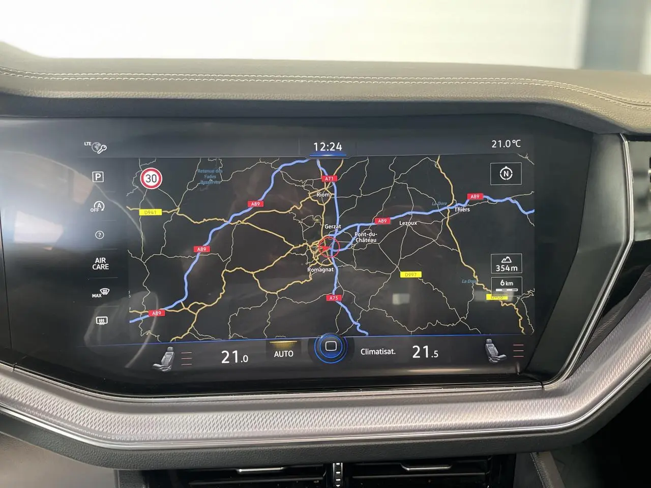 Écran tactile central du Volkswagen Touareg 2019 affichant la navigation et la climatisation, entouré de finitions argentées.