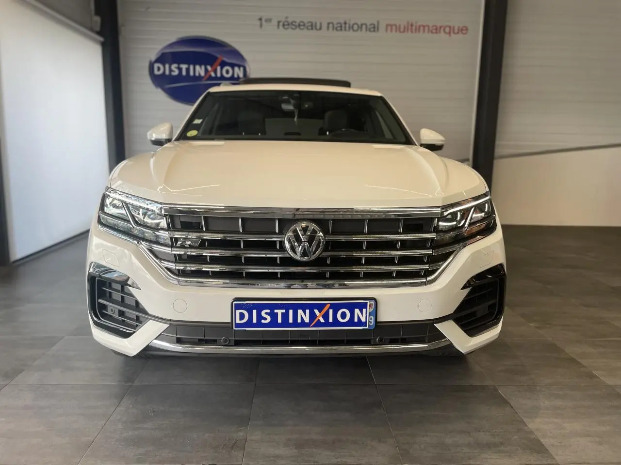 Vue frontale d’un Volkswagen Touareg blanc 2019 avec calandre chromée et logo VW bien visible.