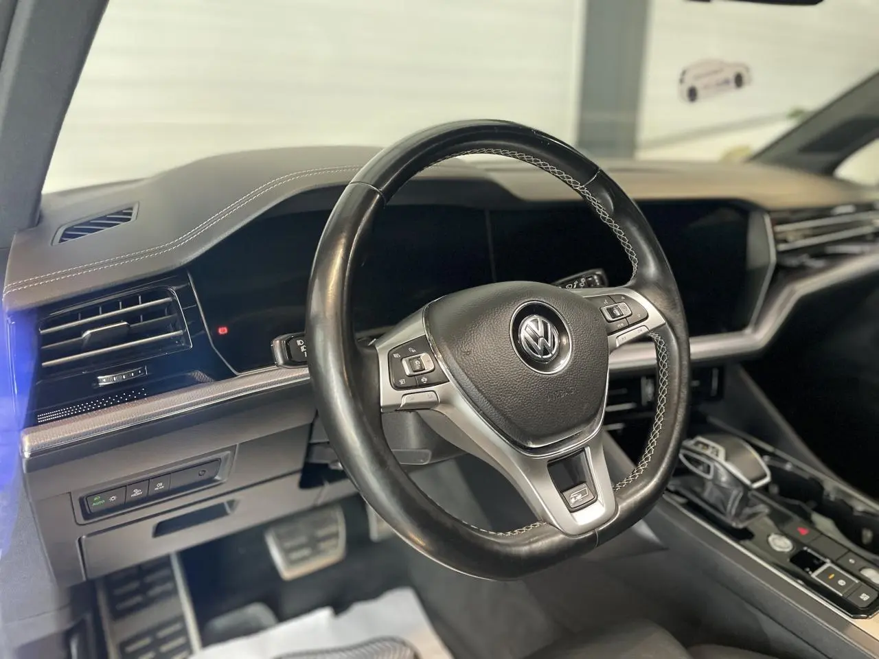 Vue intérieure du volant cuir noir multifonction Volkswagen avec tableau de bord et console centrale du Touareg 2019.