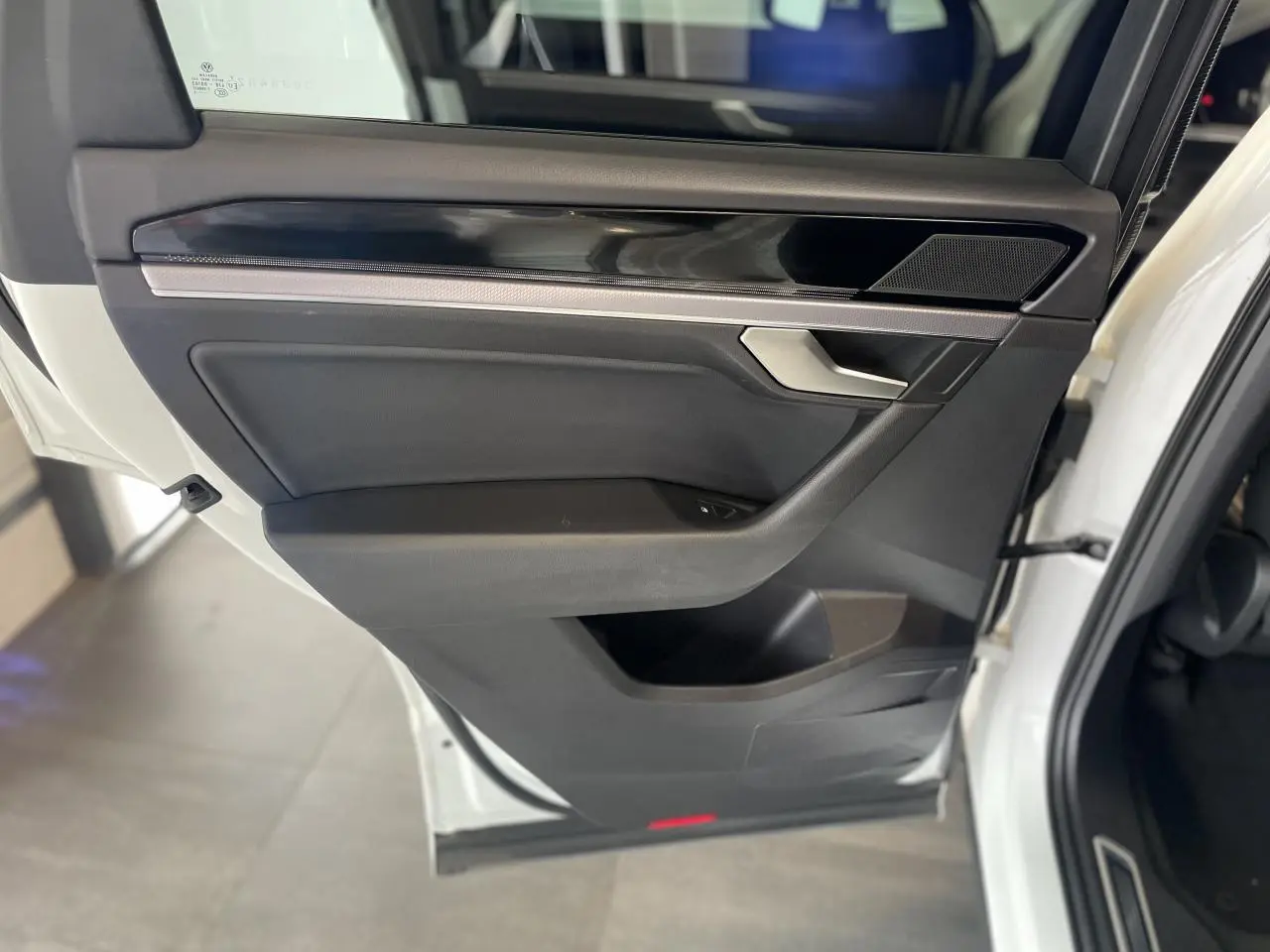 Vue intérieure côté gauche de la porte arrière blanche du Volkswagen Touareg 2019 avec garniture noire et insert laqué piano.