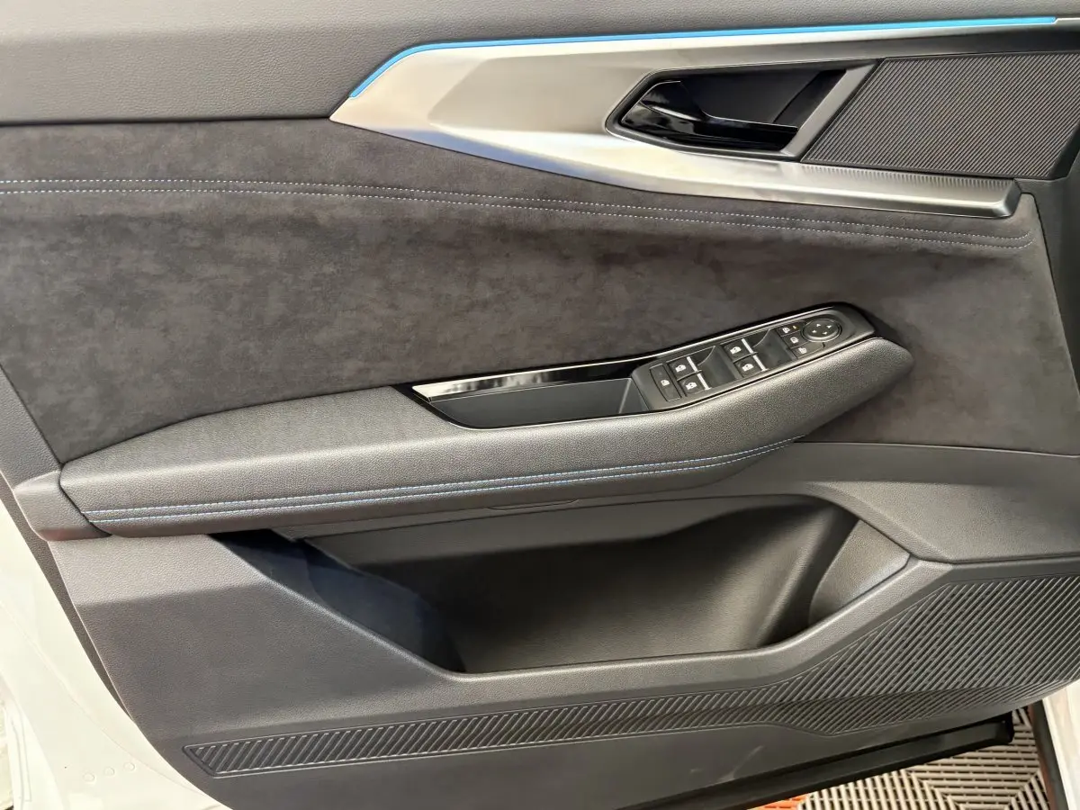 Détail de la porte avant gauche du Renault Espace blanc 2025, avec garniture noire et commandes de vitres intégrées.