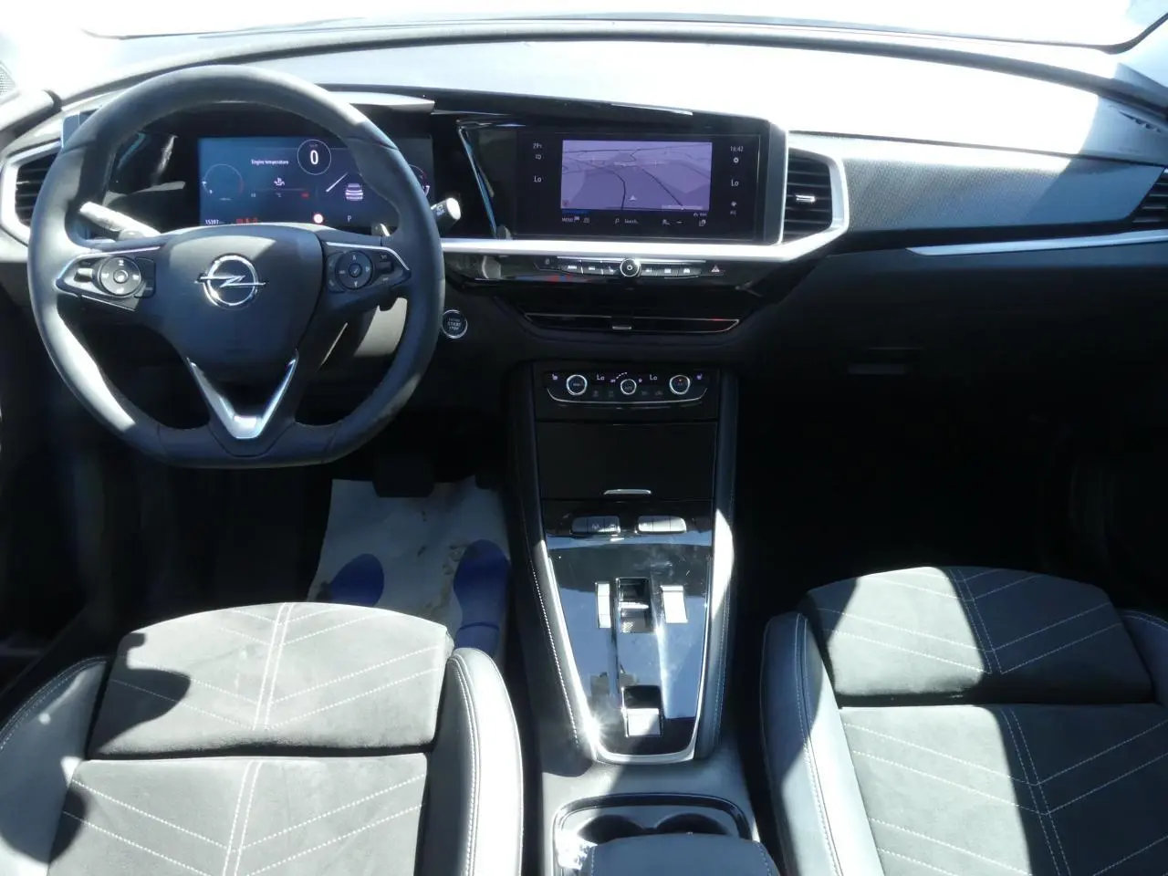 Vue intérieure frontale de l’Opel Grandland 2024 avec sellerie Alcantara noire et tableau de bord moderne.